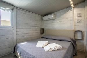a bedroom with a bed with towels on it at Luxury Bungalow in Villaggio Azzurro +19 photos