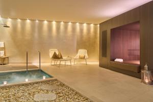 - un hall d'accueil avec un bain à remous et un lit dans l'établissement Limmathof Baden - Boutique Haus & Spa, à Ennetbaden