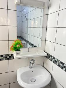 a bathroom with a sink and a mirror at Chambre moderne avec cuisine à Bonamoussadi (Kotto) in Douala