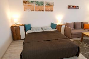 sypialnia z łóżkiem i kanapą w obiekcie Panoráma Apartman w mieście Veszprém