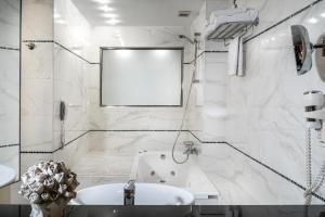 a white bathroom with a tub and a sink at Danai Hotel & Spa in Olympic Beach