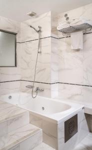 a white bathroom with a tub and a sink at Danai Hotel & Spa in Olympic Beach