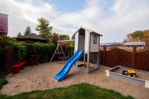 a playground with a slide and a play house at Apartamenty Rodzinne Łukęcin in Łukęcin