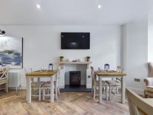 a dining room with two tables and a fire place at Driftwood Boutique Guest House in Rhosneigr