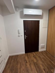 a door in a room with a hallway with wood floors at Sosnowe Apartamenty - Marina in Augustów