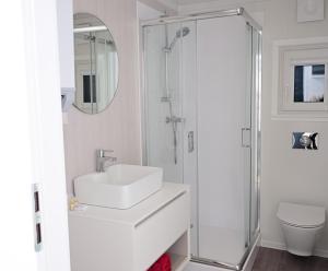 a white bathroom with a sink and a shower at Altes Kurhaus Landhotel in Trabelsdorf