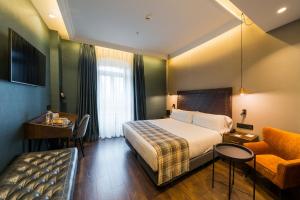 a hotel room with a bed and a chair at Catalonia Donosti in Donostia-San Sebastián