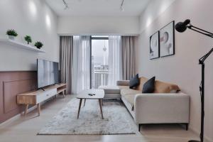H&N Luxury Suites KLCC في كوالالمبور: غرفة معيشة مع أريكة وطاولة