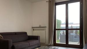 un soggiorno con divano e porta scorrevole in vetro di Casa alle porte di Pavia a Pavia