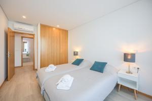 a hotel room with two beds with towels on them at Alameda 74 Luxury Apartment & Parking by Home Sweet Home Aveiro in Aveiro