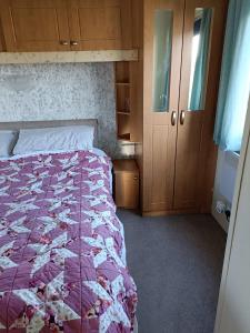 een slaapkamer met een bed met een paarse quilt bij Stevies van in Tunstall