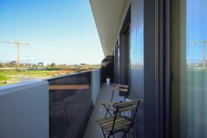 a balcony with chairs and a view of a building at Alameda 74 Luxury Apartment by Home Sweet Home Aveiro in Aveiro