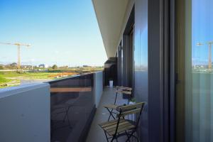 d'un balcon avec des chaises et une vue sur un bâtiment. dans l'établissement Alameda 74 Luxury Apartment by Home Sweet Home Aveiro, à Aveiro