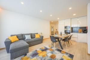 Sala de estar con sofá gris y mesa en Alameda 74 Luxury Apartment by Home Sweet Home Aveiro, en Aveiro