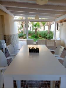 una mesa blanca y sillas en un patio en The Garden House alla Scala dei Turchi, en Realmonte