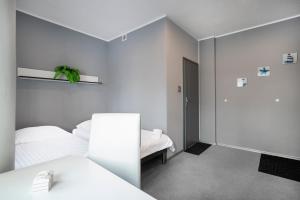 Habitación blanca con 2 camas y espejo. en Keja Aparts - 03 Gdynia Centrum, en Gdynia