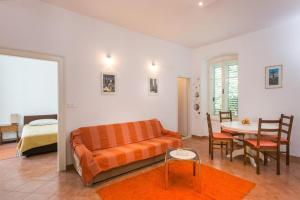 sala de estar con sofá naranja y mesa en Apartment Tranquilo, en Dubrovnik