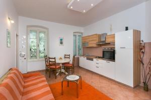 cocina y sala de estar con sofá y mesa en Apartment Tranquilo, en Dubrovnik