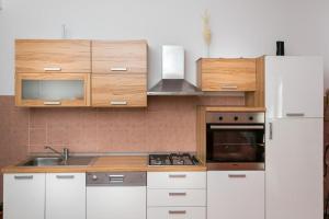 cocina con armarios blancos y nevera blanca en Apartment Tranquilo, en Dubrovnik