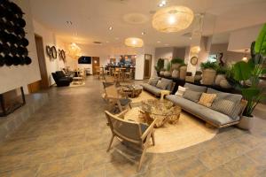 sala de estar con sofás, sillas y chimenea en Alcaidesa Boutique Hotel en Alcaidesa