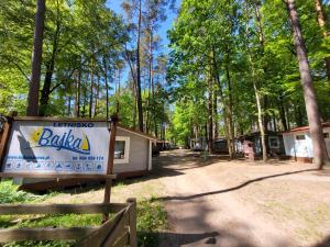 a cabin in the woods with a sign in front of it at Letnisko BAJKA in Iława