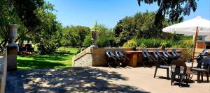 a group of chairs and an umbrella on a patio at The Darling Farmstyle B&B in Krugersdorp