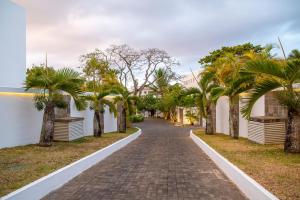 a cobblestone street with palm trees on either side at Villa Horizon by Dream Escapes, Beachfront Villa in Pointe aux Cannoniers