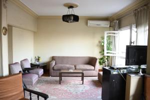 a living room with a couch and a tv at Agouza NileView Apartment in Cairo