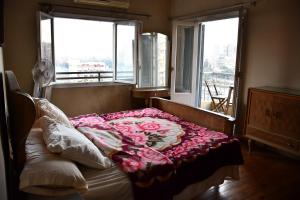 a bedroom with a bed with flowers on it at Agouza NileView Apartment in Cairo