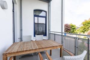 a balcony with a wooden table and chairs at Apartment Wilhelmine in Borkum