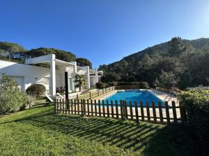 a house with a fence around a swimming pool at Villa Glamour in Santa Cristina d'Aro