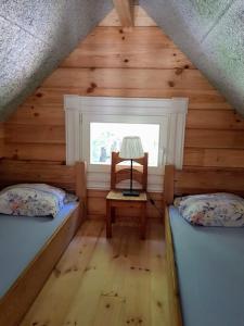 - une chambre avec 2 lits et une chaise dans une cabine dans l'établissement Namelis su ofuro vonia prie Plateliu ežero, à Medsėdžių