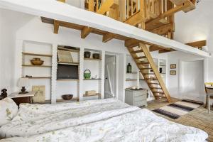 a bedroom with a large bed and a staircase at Lillemøllens bed & breakfast in Ørbæk