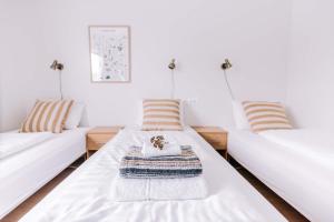 Duas camas numa sala de estar com almofadas listradas em Eldá apartments em Myvatn