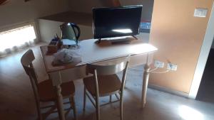 un escritorio con un monitor de ordenador encima en Affittacamere ADELPHIA, en Guastalla