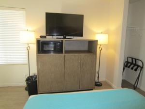a bedroom with a flat screen tv on top of a cabinet at Carousel Beach Inn in Santa Cruz