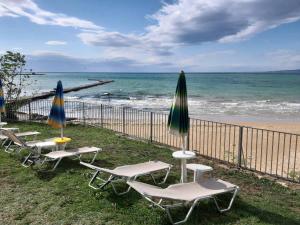 a group of lawn chairs and umbrellas next to the beach at Helios Hotel in Balchik