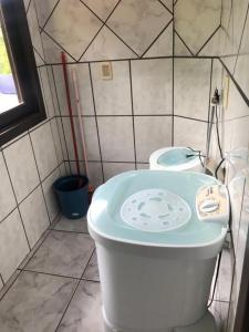 La petite salle de bains est pourvue d'une baignoire et d'un lavabo. dans l'établissement Praia da Lagoinha - Mestre Naro, à Bombinhas