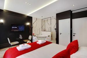 a bedroom with a red and white bed and a bathroom at Couples Getaway Unit with Jacuzzi - City Center in Paris