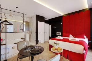 a bedroom with a red bed and a bathroom at Couples Getaway Unit with Jacuzzi - City Center in Paris