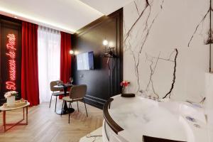 La salle de bains est pourvue d'une baignoire et d'une table avec des chaises. dans l'établissement Couples Getaway Unit with Jacuzzi - City Center, à Paris