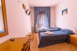 ディマーロにあるHotel Sancamilloのベッドルーム(青いベッド1台、テーブル、椅子付)