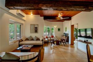 uma sala de estar com um sofá e uma mesa em SaffronStays Boulevard RockHouse - pool villa with amazing nature views em Lonavala