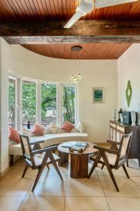 uma sala de estar com um sofá e uma mesa em SaffronStays Boulevard RockHouse - pool villa with amazing nature views em Lonavala