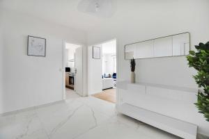 una sala de estar blanca con paredes blancas y suelo de mármol blanco. en Paris 15 Elegance & Terrace, en París