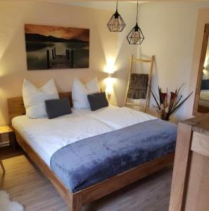 1 dormitorio con 1 cama grande con sábanas y almohadas blancas en Haus Herzog, en Bad Steben