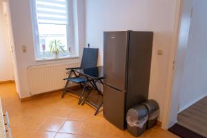 eine Küche mit einem Kühlschrank sowie einem Tisch und Stühlen in der Unterkunft Ferienwohnung Heinrich in Kröslin