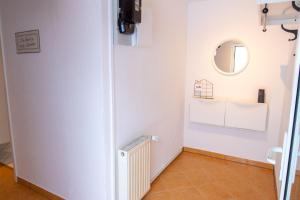Zimmer mit einem Heizkörper und einem Spiegel in der Unterkunft Ferienwohnung Heinrich in Kröslin