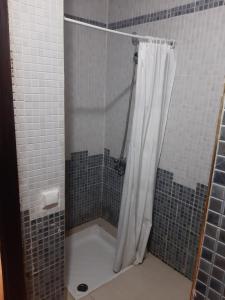 a shower with a white shower curtain in a bathroom at Duplex Riad Sidi Bouzid in El Jadida