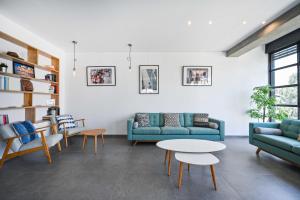 uma sala de estar com sofás, uma mesa e cadeiras em Luna Moona by HolyGuest em Tel Aviv